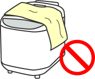 A rice cooker was used covered with a dishcloth/a towel, causing incomplete combustion and the burning of the equipment.